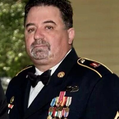 Two veterans in military uniforms standing next to each other.