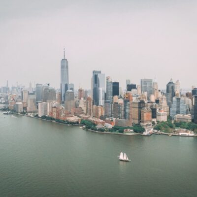 Aerial view of manhattan skyline with sailboats in the water.
