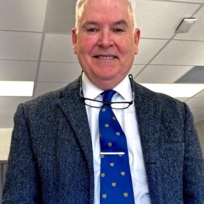 A man wearing glasses and a blue tie.