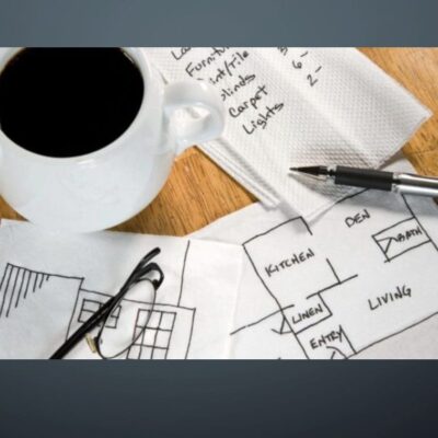 A cup of coffee with a pen and paper on a table.