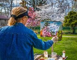 Artist painting in a blooming spring garden.