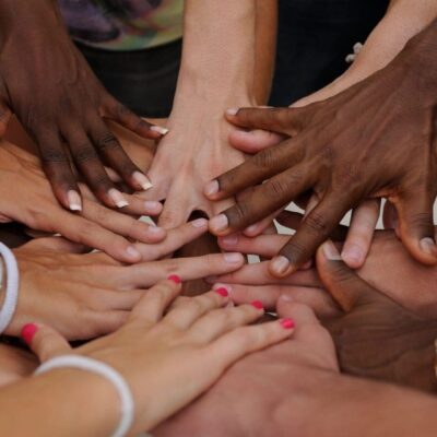 A group of people putting their hands together in a circle.