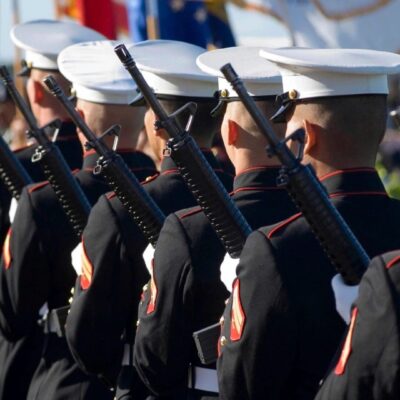 Marines in formation holding rifles during a ceremony.
