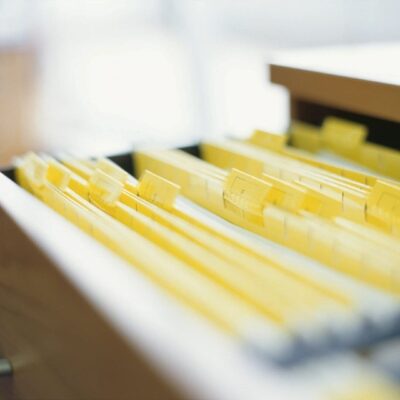 A drawer full of yellow file folders on a desk.