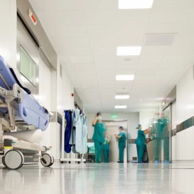 Medical staff in scrubs converse in a hospital corridor.