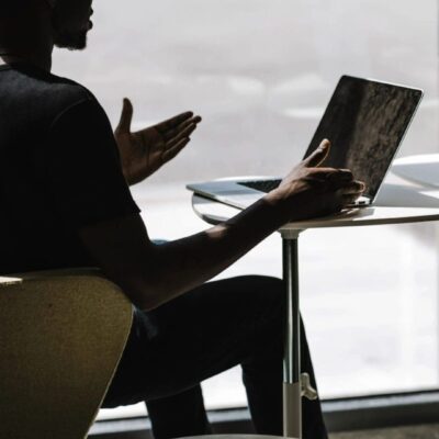 Man using laptop, giving presentation.