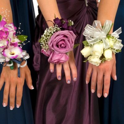 A group of bridesmaids wearing flowers on their wrists.