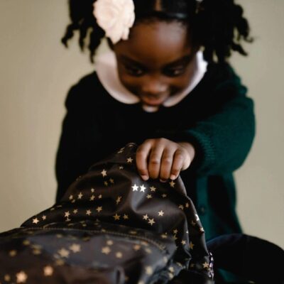 Girl opening star-patterned backpack.