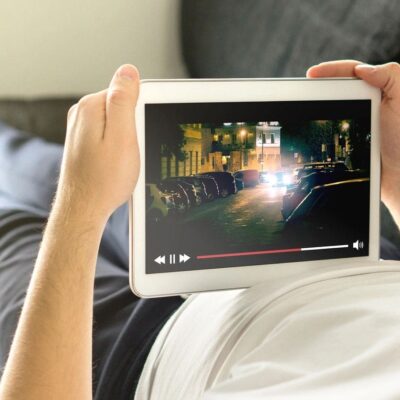 Person watching a cityscape video on a tablet while relaxing.