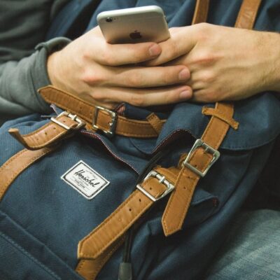 Person using phone, Herschel backpack.