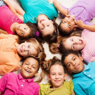 Happy diverse children lying in a circle.