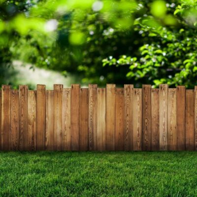 A wooden fence in the middle of a yard.