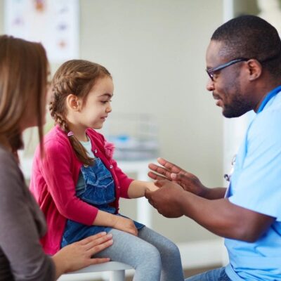 A young girl is being examined by a doctor.