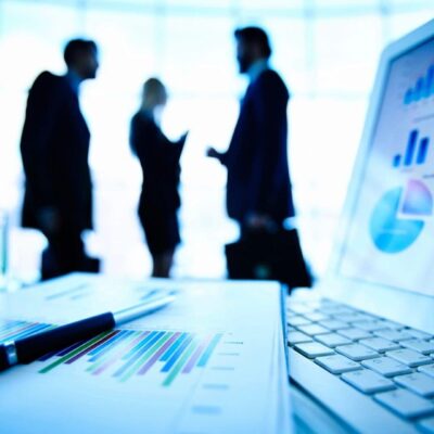 Businesspeople meeting, charts, and laptop.