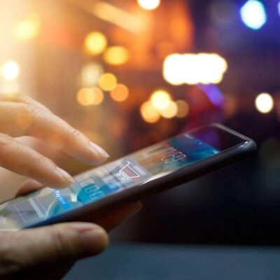 A person using a smartphone in front of a crowd.