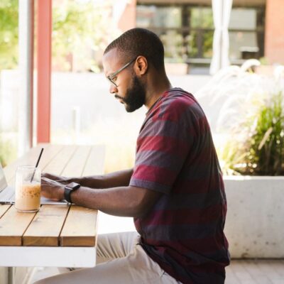 A man sitting at a table working on his laptop.