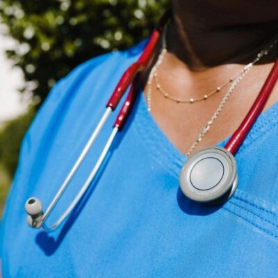 A nurse wearing a blue scrub top and stethoscope.
