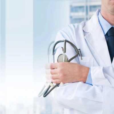 Doctor holding stethoscope in hospital setting.