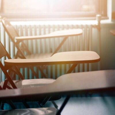 A row of classroom chairs in front of a window.