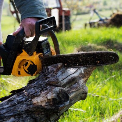 A man cutting a log with a chainsaw.