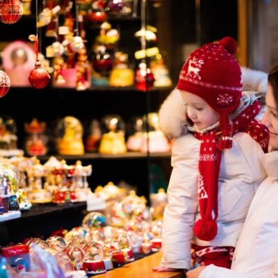 A woman and child looking at christmas ornaments in a store.