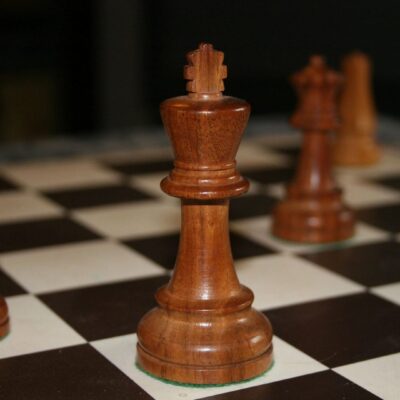 Wooden chess pieces on a chess board.
