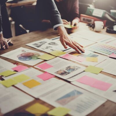 A group of people sitting around a table with sticky notes.