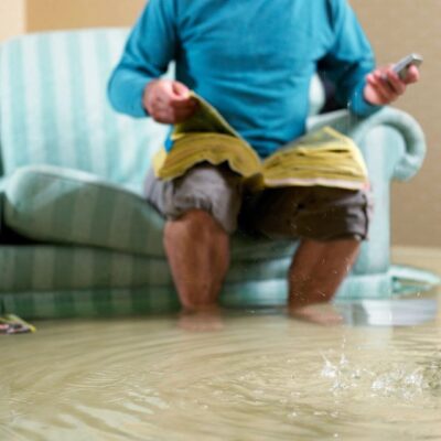 Man reading on flooded sofa.