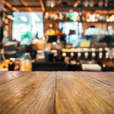 Wooden table, blurred cafe background.