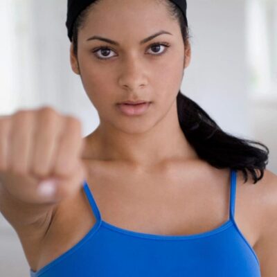 Woman in blue top with fist raised.