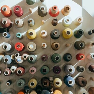 Top view of various colorful thread spools arranged closely together.