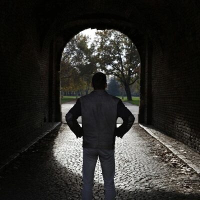 A man standing in a dark tunnel.