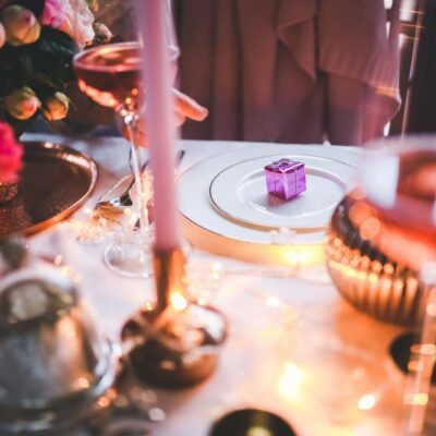 Elegant dinner table set with candlelight and flowers.