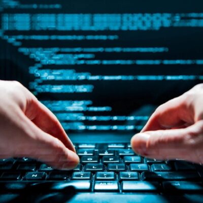 Two hands typing on a computer keyboard.