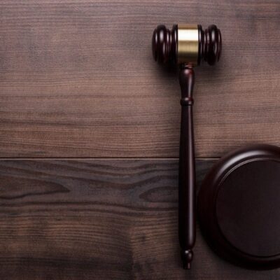 A wooden gavel on top of a wooden table.
