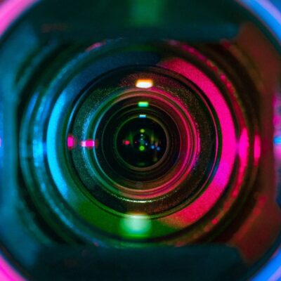 A close up of a camera lens with colorful lights.