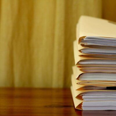 A stack of papers on a wooden table.