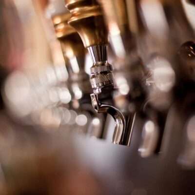Here's an alt tag for the image: Beer taps at a bar.
