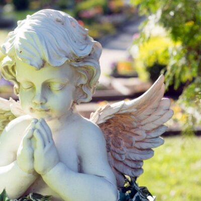 A statue of an angel with hands in prayer.