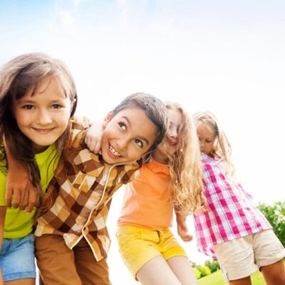 A group of children playing together in a grassy field.