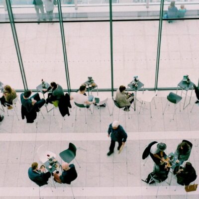 People sitting at tables near a window.