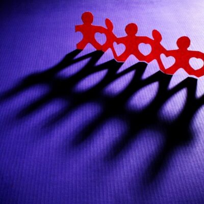 Red shadows of people on a blue background.