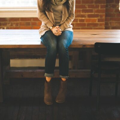 A woman sitting on a wooden table.