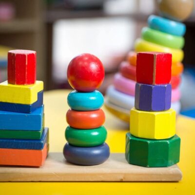 A stack of colorful blocks on a table in a child's playroom.