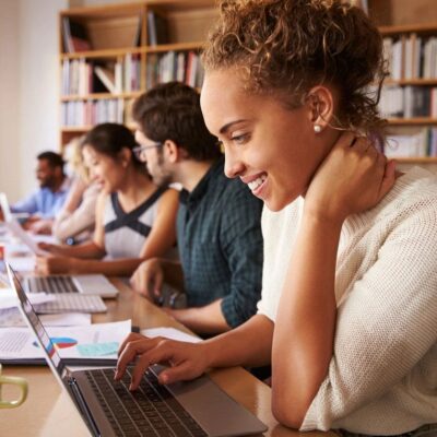 Woman working on laptop in office.