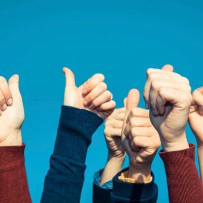 A group of people raising their hands in the air.