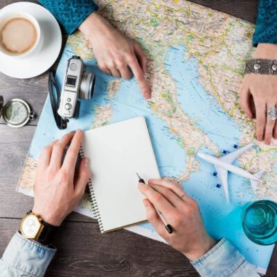 Two people looking at a map with a cup of coffee.