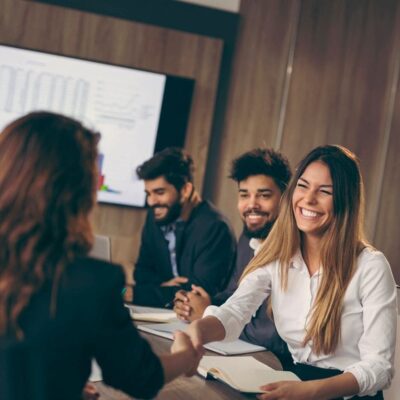 A group of business people shaking hands in a meeting room.