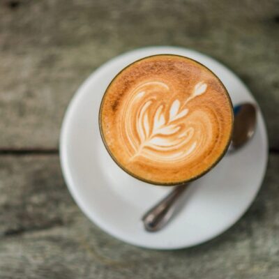 Latte art in a glass on saucer.