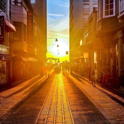 The sun is setting over a city street.